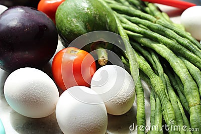 Fresh various raw organic vegetables with white eggs display for healthy and diet background. Stock Photo