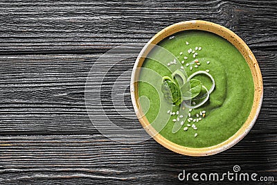 Fresh vegetable detox soup made of spinach in dish on wooden background, top view Stock Photo