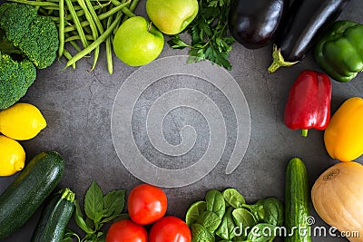 Fresh vegetables, fruits, herbs on dark stone table Frame of fresh veggies. Mockup for menu or recipe. Spring vitamins Stock Photo