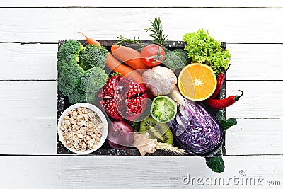 Fresh vegetables and fruits in a wooden box on a white wooden background. Organic food. Stock Photo