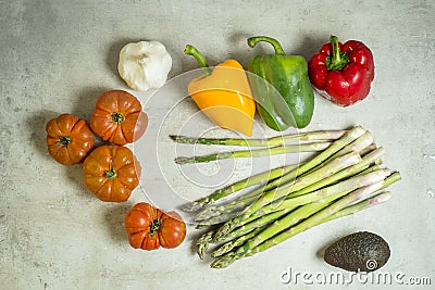 Fresh vegetables on table, tomatoes, garlic, asparagus, avocado Stock Photo