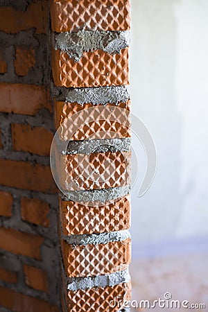 Fresh vertical brick course of a row of brickwork with a mortar joint between each brick of masonry mortar Stock Photo