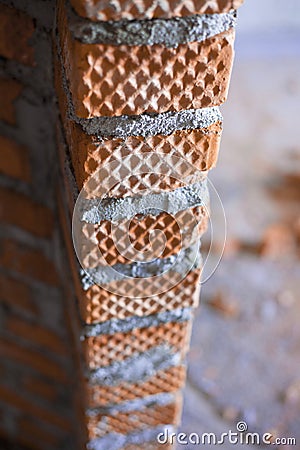 Fresh vertical row of brickwork with a cement mortar joint between each brick Stock Photo