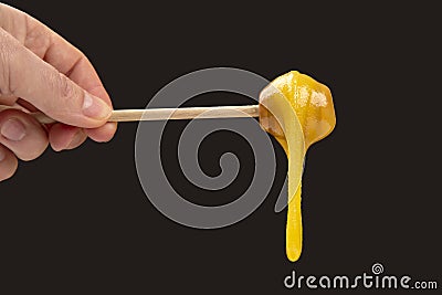 Fresh viscous flower honey falls down from a wooden spoon. vitamin organic food Stock Photo