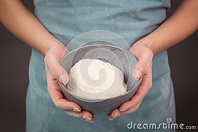 Fresh wheat dough, baker holds bowl with flour, bread or pizza, prepare ingredients for food, baking pastry Stock Photo