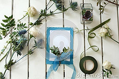 Fresh white roses and wedding invitation card on white wooden ta Stock Photo