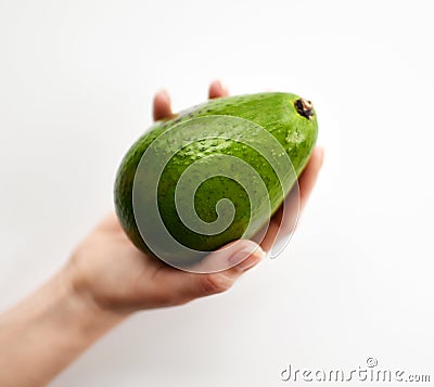 Fresh whole avocado in woman hand slices on white background Stock Photo