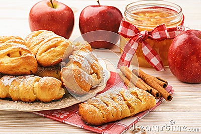 Fresh yeast buns with apple jam and cinnamon on white wooden background. Stock Photo