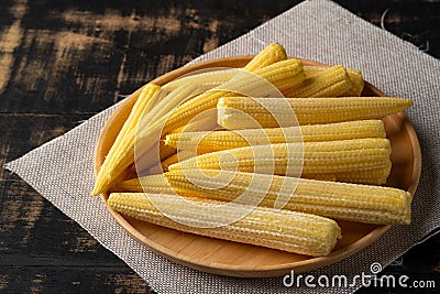 Fresh young baby corn on wooden plate background Stock Photo