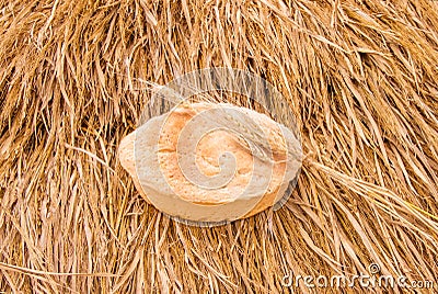 Freshly baked bread and wheat spikelets on haystack. Stock Photo