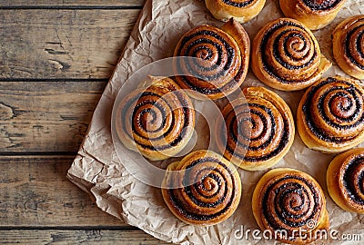 Freshly baked cinnamon buns with spices and cocoa filling on parchment paper. Sweet Homemade Pastry christmas baking. Stock Photo