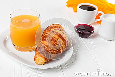 Freshly baked croissant orange juice, jam, cup of black coffee on white wooden background. French breakfast. Fresh pastries for mo Stock Photo