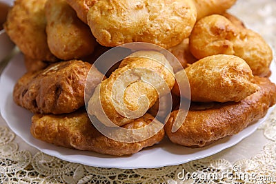Freshly baked delicious pies with a brown crispy crust lie on a white ceramic plate. Stock Photo