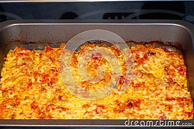 Freshly baked fish, meat and vegetable casserole with tomatoes and cheese Stock Photo