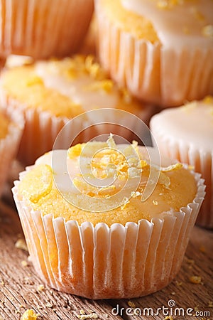 Freshly baked lemon muffins with frosting macro. Vertical Stock Photo