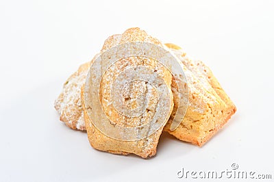 Freshly baked Madeleine cookies sprinkled with sugar powder close-up on the table, petite madeleine isolated on white backgrou Stock Photo