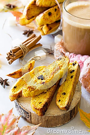 Freshly baked raisins and cinnamon biscotti and a cup of cappuccino coffee on a gray slate or slate background Stock Photo