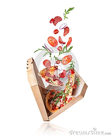 Freshly baked spicy pizza with ingredients in the air on a white background Stock Photo