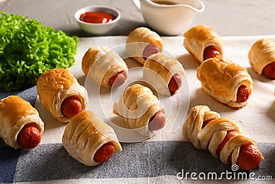 Freshly baked tasty sausage rolls on table Stock Photo