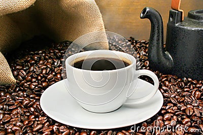 Freshly brewed coffee cup over rosated beans Stock Photo