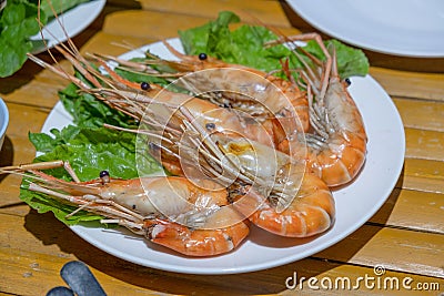 Freshly burned shrimp In a tile dish on a bamboo table Stock Photo