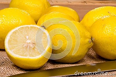 Freshly cut lemons on a ocher texture with a knife Stock Photo