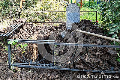 Freshly dug empty grave in old cemetery Stock Photo