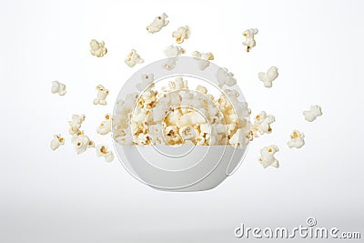 Freshly made crispy popcorn fall in pile on white background. Creative concept of floating healthy snacks. Stock Photo