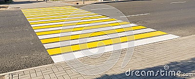 Freshly painted pedestrian crossing with yellow and white markings on asphalt, sunlight Stock Photo