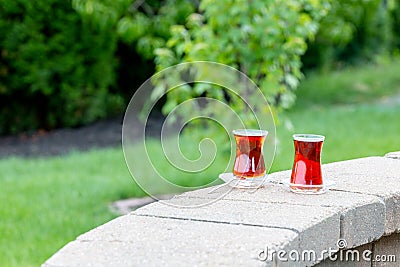 Glasses with hot Turkish tea on brick parapet wall Stock Photo
