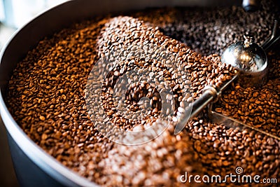 Freshly roasted coffee beans from a large roaster in the cooling cylinder. Motion blur on beans. Stock Photo