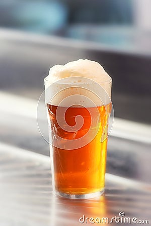 Fresh served pint of frothy draft beer in a glass Stock Photo