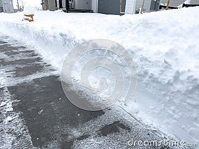 Cleared Pathway Amidst Snowy Suburban Landscape Stock Photo