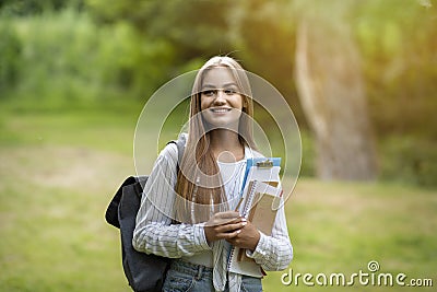 Freshman Girl. Beautiful Female College Student With Workbooks And Backpack Posing Outdoors Stock Photo