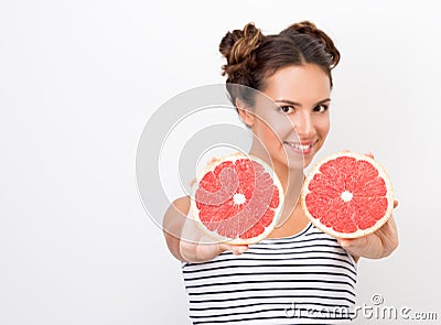 Freshness and vivacity. Young cheerful woman showing red halves of grapefruit Stock Photo