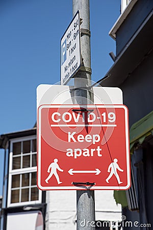 Covid-19 red sign relating to keeping apart Stock Photo