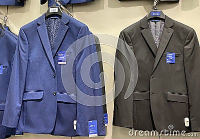 2021 New Mens dress suits / jackets hanging on store hooks blue and black color Editorial Stock Photo