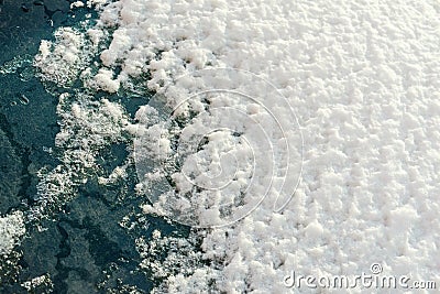 Friable texture of sparkling snow on glass Stock Photo