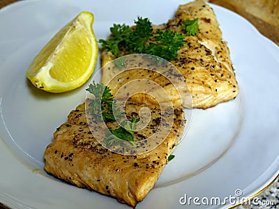 Fried arctic char trout fish fillets on white plate Stock Photo