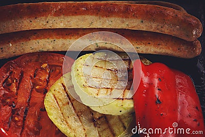 Fried barbecue sausages near to grilled vegetables Stock Photo