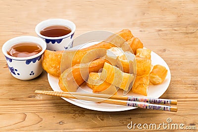 Fried bread stick or You Tiao served with Chinese tea on wooden table Stock Photo