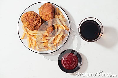 Fried breaded crispy chicken nuggets with French fries on wooden plate, ketchup and soft drink on the side Stock Photo