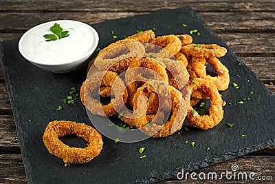 Fried Breaded Onion Rings with sauce on stone board Stock Photo