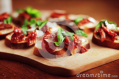 Fried bruschetta with dried tomatoes, basil and cream cheese. Stock Photo