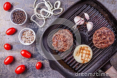 Fried burger beef cutlets with vegetables on grill pan on gray marble background Stock Photo