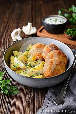 Fried cauliflower and cheese croquettes with boiled potatoes and sour cream dip Stock Photo