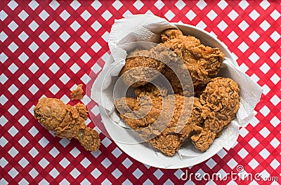 Fried Chicken basket on red and white checkered table with drumstick Stock Photo