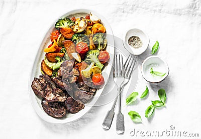 Fried chicken liver and baked seasonal vegetables - delicious healthy lunch on light background, top view Stock Photo