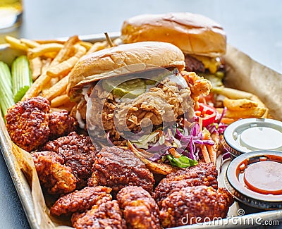 Fried chicken sandwich and cheeseburger in tray with fries and boneless wings Stock Photo