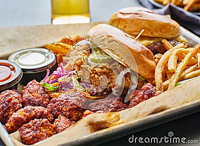 Fried chicken sandwich and cheeseburger in tray with fries and boneless wings Stock Photo